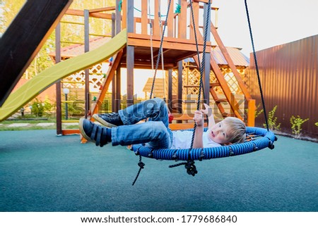 A small blond boy plays on a Playground on a Sunny summer day