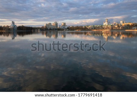 city reflected in a pond with clouds and church
