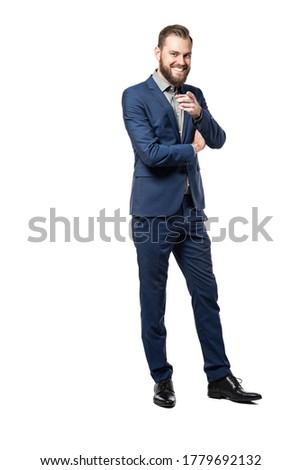 A full body picture of a happy caucasian male smiling and pointing at the camera, wearing a
blue suit standing against a white background.