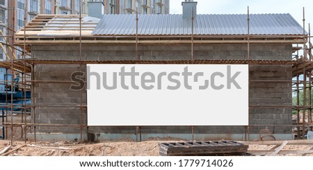 large white empty sign board on wall of temporary house on construction site mock-up scaffold background front view