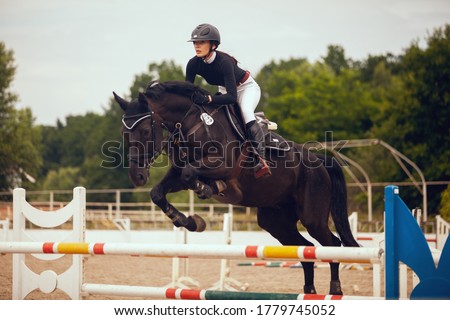 Equestrian sport - young girl rides on horse. Royalty-Free Stock Photo #1779745052