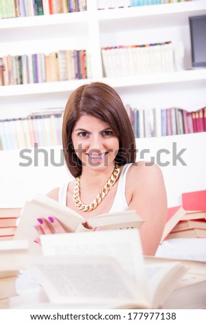 beautiful smiling girl studying and reading books