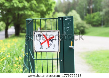 A "No pets allowed" sign attached on a green gate