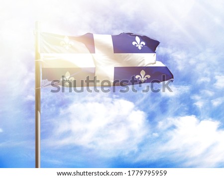 National flag of Quebec on a flagpole in front of blue sky