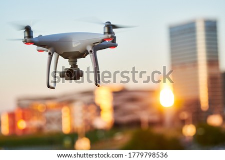 drone with digital camera flying at city street