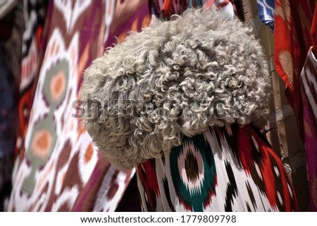 Traditional Uzbek hat and dyed silk in a shop in the historical city of Bukhara, Uzbekistan. Royalty-Free Stock Photo #1779809798