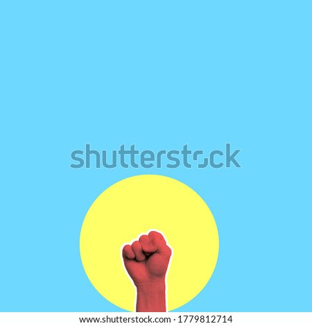 A protesting man. The man raised his fist in the air, fighting for his rights, on a yellow background. The concept of revolution or protest.