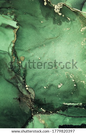 Luxury abstract fluid art alcohol ink background in a green color with a liquid gold paint. Art for your design project. Closeup of the painting