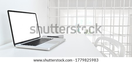 Modern decor of workspace with laptop and notebook on white background in home office.