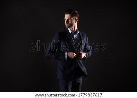 Portrait of his he nice attractive elegant guy shark banker financier director fastening button dressing going to meeting conference corporate appointment isolated on dark black color background