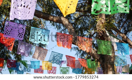 Colorful mexican perforated papel picado banner, festival colourful paper garland. Multi colored hispanic folk carved tissue flags, holiday or carnival. Authentic fiesta decoration in Latin America. Royalty-Free Stock Photo #1779853274