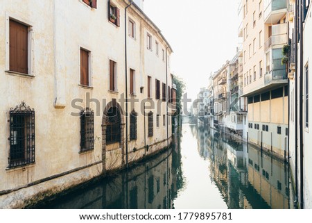 View of old houses and their reflection in a water canal Padua.