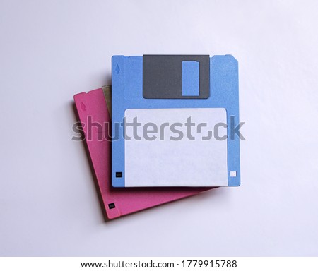 Two floppy disks 3.5 inch that pink and blue for old computer data storage and outdated technology.                               