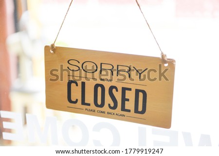 Closed shop sign / Sorry we're closed sign hanging on cafe glass door