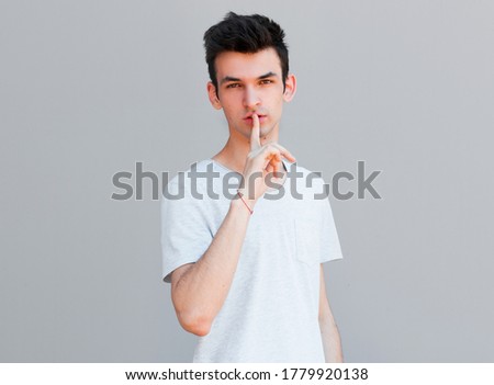 Young handsome man bagging keep secret isolated