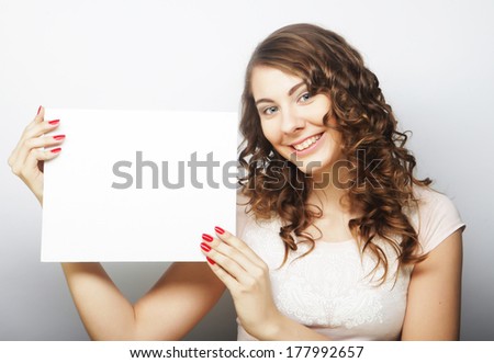Young curly woman holding blank card
