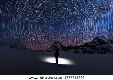 Circular Star trails facing north with Polaris the north star in centre and a silhouette human watching the stars move