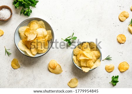 Homemade  potato chips in bowls.  Oven baked crispy potato chips on white background, top view, copy space. Royalty-Free Stock Photo #1779954845