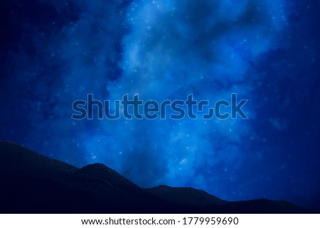 Photo of the night sky with the milky way and stars. The dark silhouette of the mountains. Tourism.