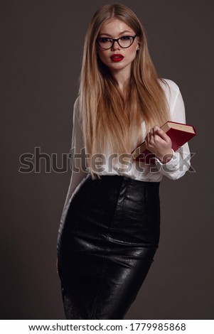 Woman teacher or business woman holding book. Female office worker wearing white shirt. Studio isolated portrait of smiling woman, business person on grey background