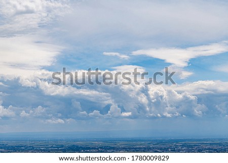 Light white clouds on blue sky. Dramatic evening sky in summer. Rural German landscape and cloudscape 