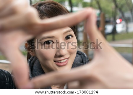 Asian young woman give you a gesture of frame for picture shot, close up portrait.