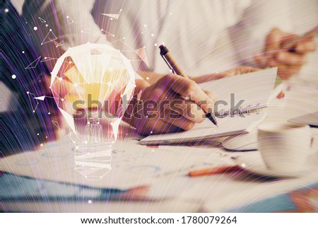 Double exposure of bulb drawing over people taking notes background. Concept of idea