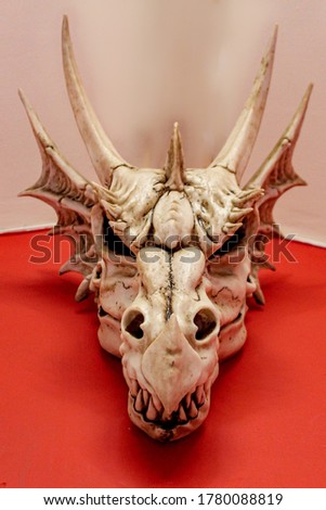 Fantasy dragon skull on red and white background 