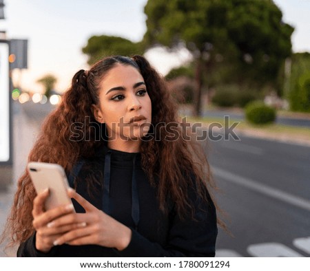 pretty afro-haired girl with mobile phone on the street