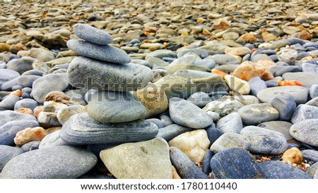 Stones balance on beach. A figure of stones on a background of the sea rocks.