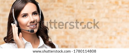 Support phone operator in headset, looking up, with blank copy space area for slogan or text message, on loft background. Consulting and assistance service call center.