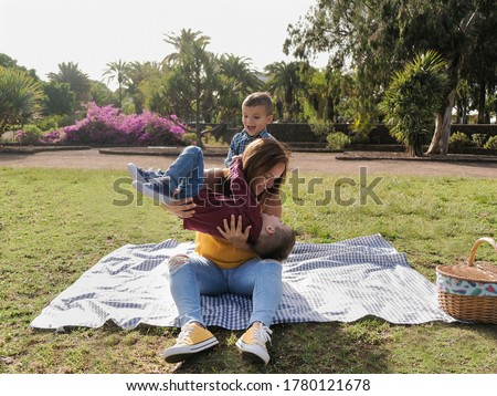 Young happy family having playful time together in a nature park with a pic nic - Mother and child love 