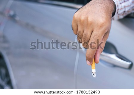 close up man hand hold smoking. Leaving cigarette out of the car while driving travel. 