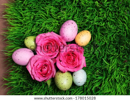 Colorful Easter Egg and Pink Roses on Green Grass
