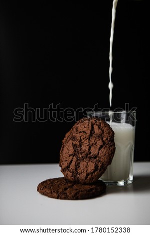 pouring milk in glass with chocolate cookies