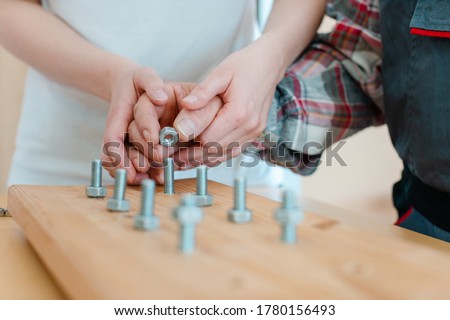 Closeup on hand of man in occupational therapy screwing nut on bolt Royalty-Free Stock Photo #1780156493