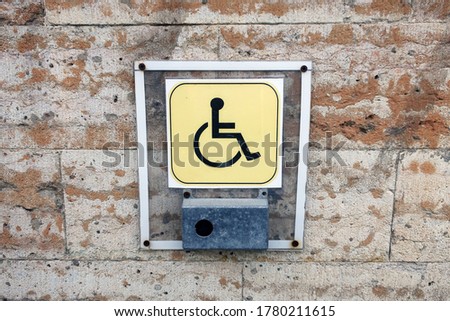 Helping a disabled person. Call button for help for disabled people. Staff call button in front of the entrance.