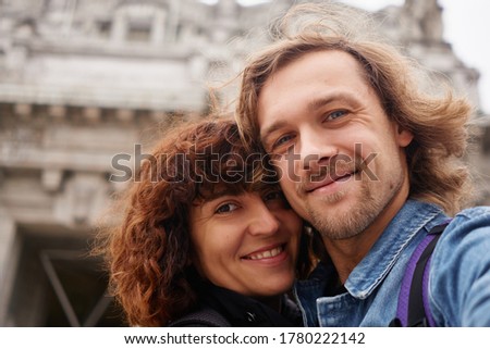 Positive smiling traveling couple making selfie on big city background, autumn colors and romantic mood. Travel, happiness and lifestyle concepts.