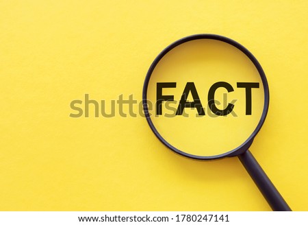Fact - Word Through Magnifying Glass on yellow table Royalty-Free Stock Photo #1780247141