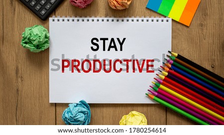 White note with inscription 'stay productive' on beautiful wooden table, colored paper, colored pencils, and calculator. Business concept.