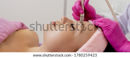 The cosmetologist makes the procedure Microdermabrasion of the facial skin of a beautiful, young woman in a beauty salon.Cosmetology and professional skin care Royalty-Free Stock Photo #1780259423