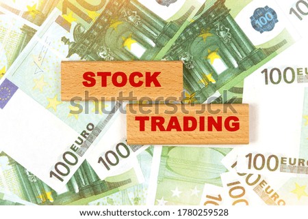 Business concept. Against the background of euro bills, the text is written on wooden blocks - stock trading