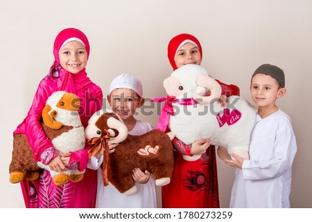 Little Muslim kids playing with sheep toys - celebrating Eid Al Adha - Happy Sacrifice Feast Royalty-Free Stock Photo #1780273259