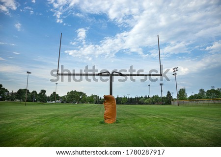 Wide angle view of a goalpost on a football field with beautiful clouds in the morning Royalty-Free Stock Photo #1780287917