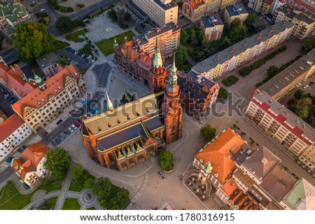 Aerial high angle view of the Cathedral of St. Peter and Paul the Apostles and old town buildings before sunset. The sun's rays beautifully highlight the urban architecture in Legnica, Poland