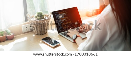 Back view of Programer Woman hands typing source code html and programming on screen laptop,development program,web design,developer abap,sap in cafe.New normal of freelance work process concept.
