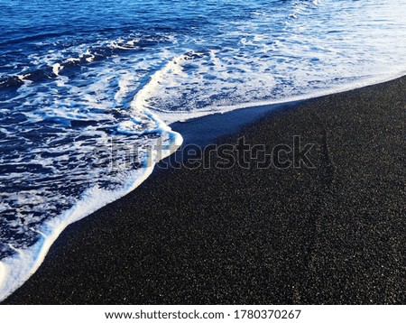 Beautiful blue waves of the Aegean sea taken on Perissa beach, Greece