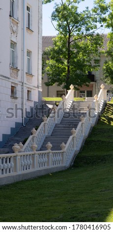 A beautiful 1950s reinforced concrete staircase with sturdy balusters and decorative pots on the railing.