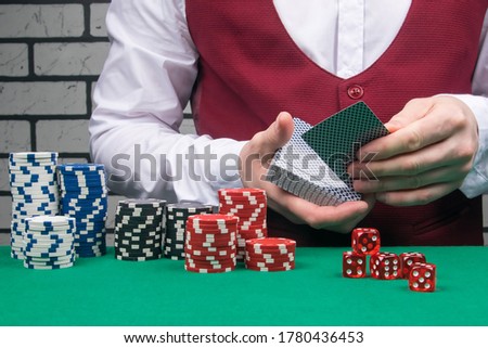 poker game concept: the croupier deals the cards, playing chips are laid out on the green cloth