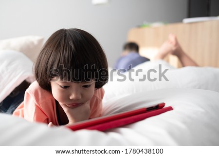 asian chinese child playing tablet, kid watching cartoon
